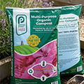 Penny Green multi-purpose organic compost bag with flowers and gardening tools in the background