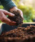 Person holding soil over a planter with a blurred garden background