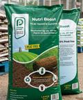 Two bags of Nutri Boost compost with a green field graphic on a blurred indoor background.