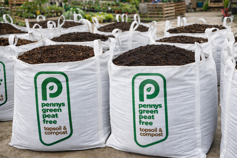 Bags of Pennys Green Peat Free topsoil and compost with visible branding.